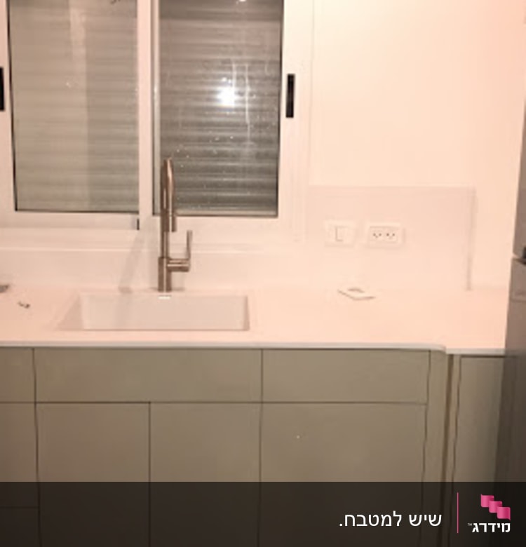 מטבח עם משטח שיש לבן וכיור